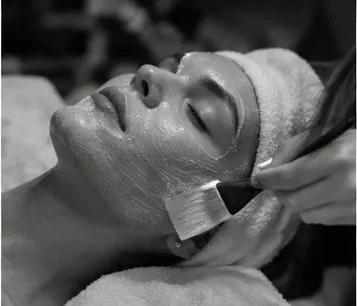 Zwart-witfoto van een gezichtsbehandeling in een beautysalon